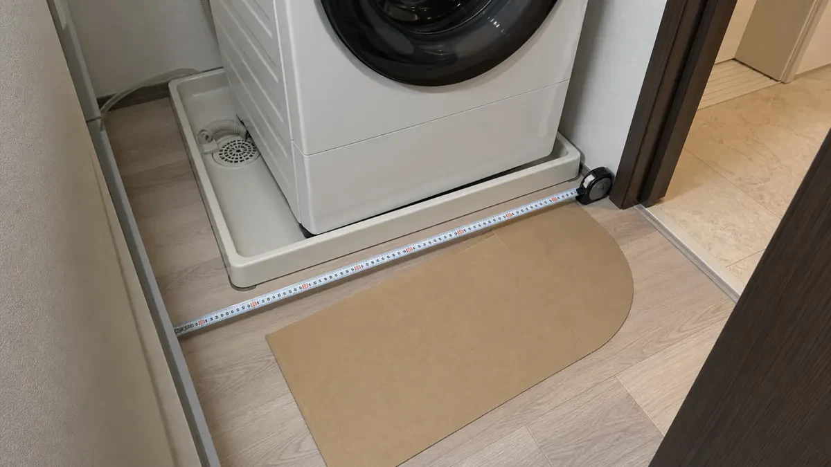 防水パンと前方スペースをメジャーで測る洗面所