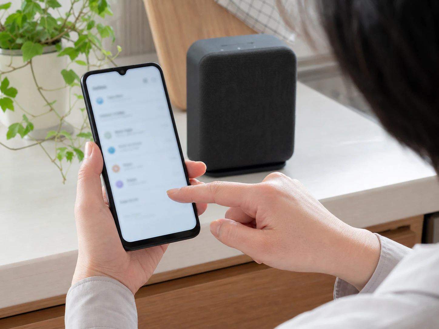 スマートフォンでGoogle Homeの設定を確認しながら玄関へ向かう場面